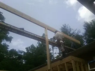Carpenter setting a ridge beam over a new addition frame — Ice Dam Removal by Roofing Brothers in Thousand Palms
