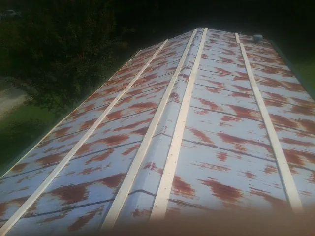 Rusted metal roof panels with new wood purlins before replacement — Storm Damage Roof Repair in Thousand Palms by Roofing Brothers