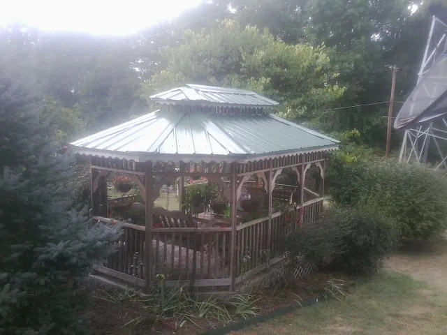 Green metal roof on a backyard gazebo surrounded by garden beds in Thousand Palms